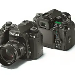 Dwa aparaty Pentax K-1 Mark II na białym tle. Jeden z przodu z obiektywem, drugi z tyłu, pokazujący ekran i przyciski.