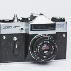 Srebrny aparat Zenit M z czarnym gripem i obiektywem Industar-50-2. Klasyka fotografii.