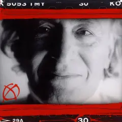 Portret mężczyzny z charakterystycznym symbolem anarchii, w stylu **William Klein**. Czerwone pociągnięcia farby dodają dynamiki.