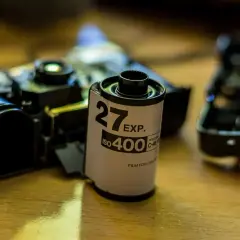 Rolka filmu 35mm ISO 400, obok rozebranego aparatu, czeka na budowę obiektywu.
