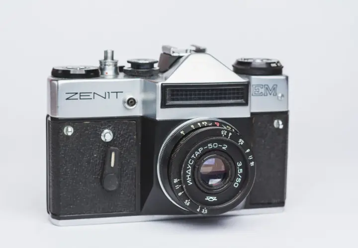 Srebrny aparat Zenit M z czarnym gripem i obiektywem Industar-50-2. Klasyka fotografii.