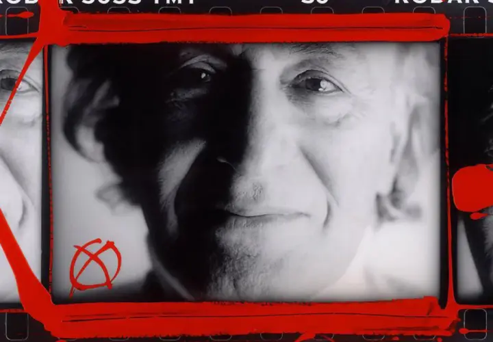 Portret mężczyzny z charakterystycznym symbolem anarchii, w stylu **William Klein**. Czerwone pociągnięcia farby dodają dynamiki.