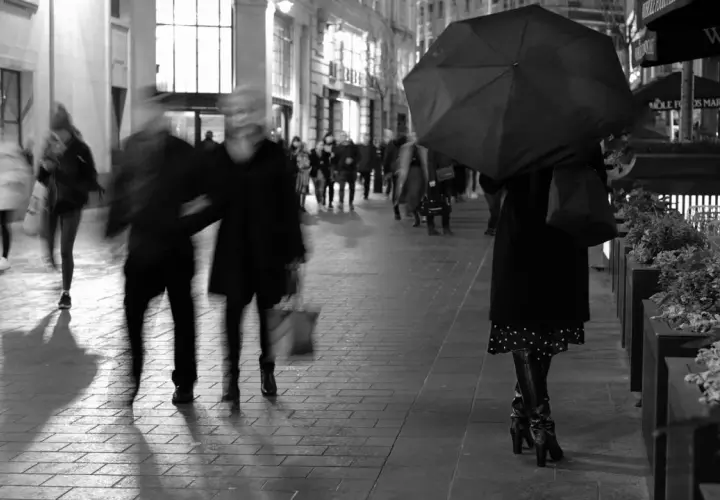 Nocna fotografia uliczna, rozmyte postacie pod parasolem i w tłumie. Czy to legalne?