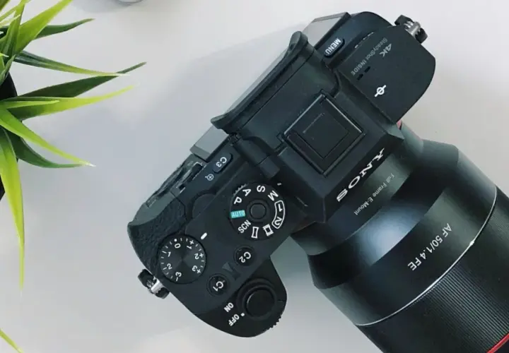 Aparat Sony z obiektywem AF 50/1.4 FE, gotowy do pracy. Ustawienia preselekcja przysłony i trybów fotografowania.