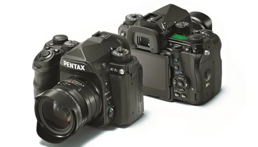 Dwa aparaty Pentax K-1 Mark II na białym tle. Jeden z przodu z obiektywem, drugi z tyłu, pokazujący ekran i przyciski.