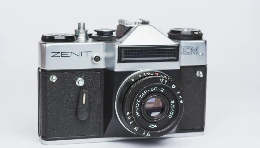 Srebrny aparat Zenit M z czarnym gripem i obiektywem Industar-50-2. Klasyka fotografii.
