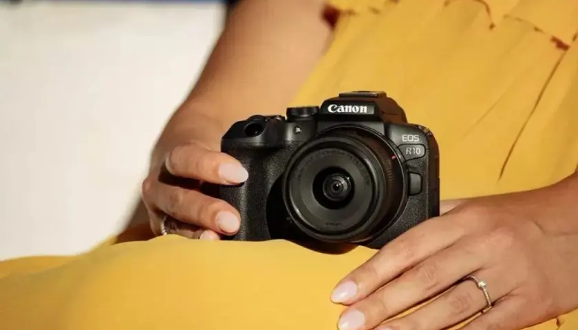 Dłonie trzymają aparat Canon EOS R10, gotowy do testów.