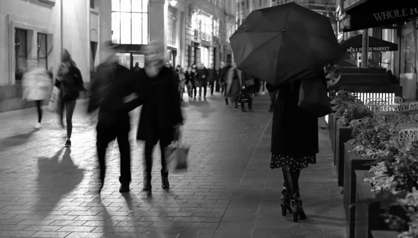 Nocna fotografia uliczna, rozmyte postacie pod parasolem i w tłumie. Czy to legalne?
