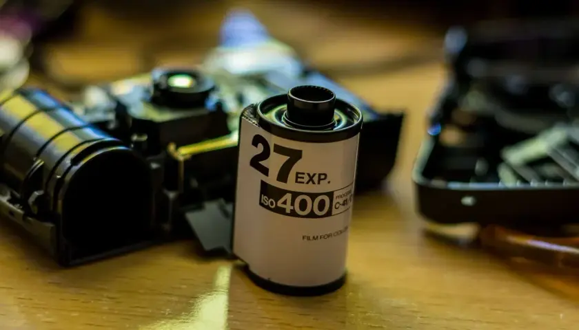 Rolka filmu 35mm ISO 400, obok rozebranego aparatu, czeka na budowę obiektywu.