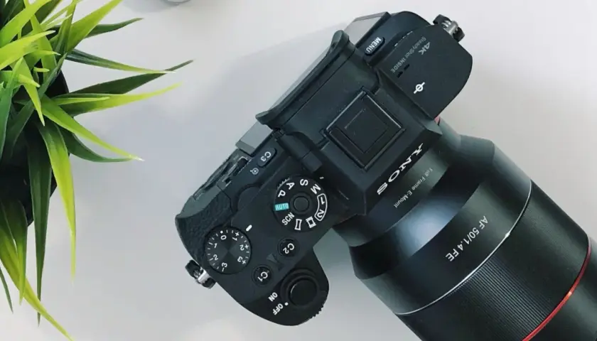 Aparat Sony z obiektywem AF 50/1.4 FE, gotowy do pracy. Ustawienia preselekcja przysłony i trybów fotografowania.