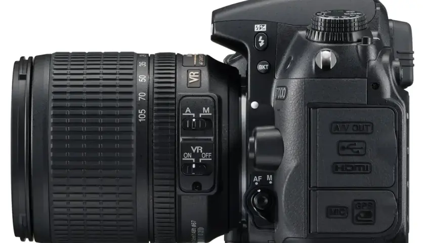 Nikon D7000 z obiektywem. Szczegółowe nikon d7000 dane techniczne widoczne na przyciskach i złączach: HDMI, MIC, GPS.