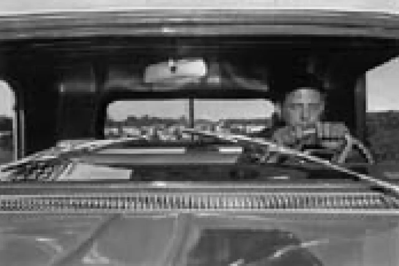 Lee Friedlander za kierownicą, patrzący przed siebie. Widok z wnętrza samochodu.