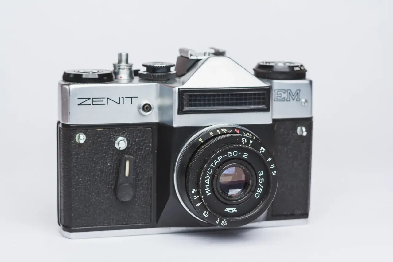 Srebrny aparat Zenit M z czarnym gripem i obiektywem Industar-50-2. Klasyka fotografii.