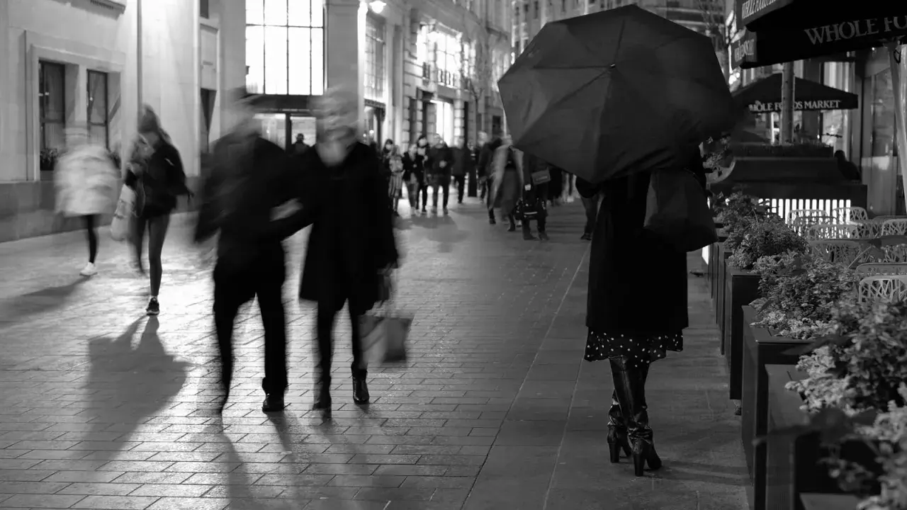 Nocna fotografia uliczna, rozmyte postacie pod parasolem i w tłumie. Czy to legalne?