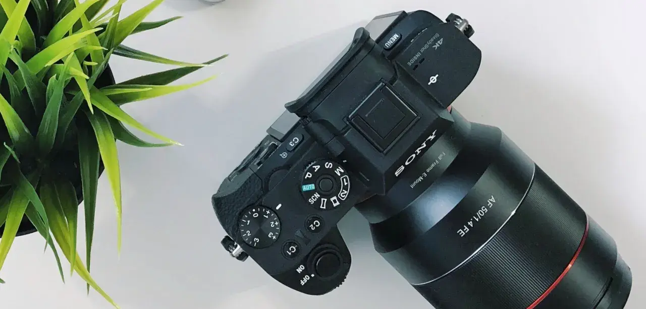 Aparat Sony z obiektywem AF 50/1.4 FE, gotowy do pracy. Ustawienia preselekcja przysłony i trybów fotografowania.
