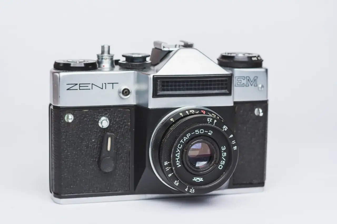 Srebrny aparat fotograficzny Zenit M z czarnym gripem i obiektywem Industar-50-2.