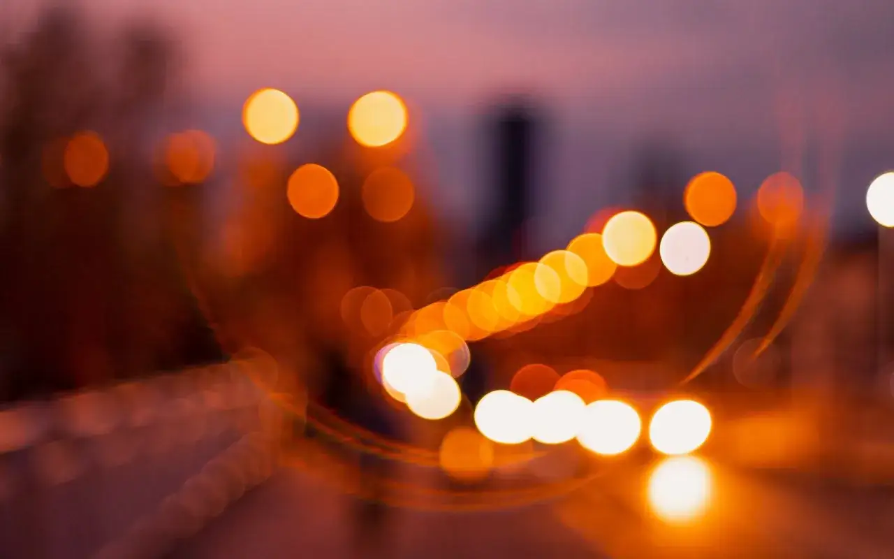 Rozmyte światła miasta tworzą magiczny efekt bokeh. To właśnie bokeh co to, czyli artystyczne rozmycie tła, kt&oacute;re nadaje zdjęciu głębi i nastroju.