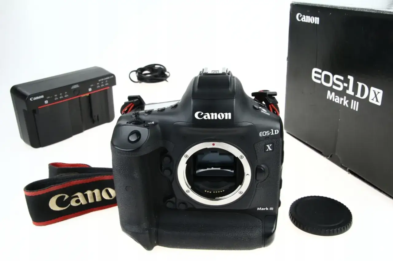 Profesjonalny aparat Canon EOS-1DX Mark III z akcesoriami: ładowarka, pasek, dekielek i pudełko.