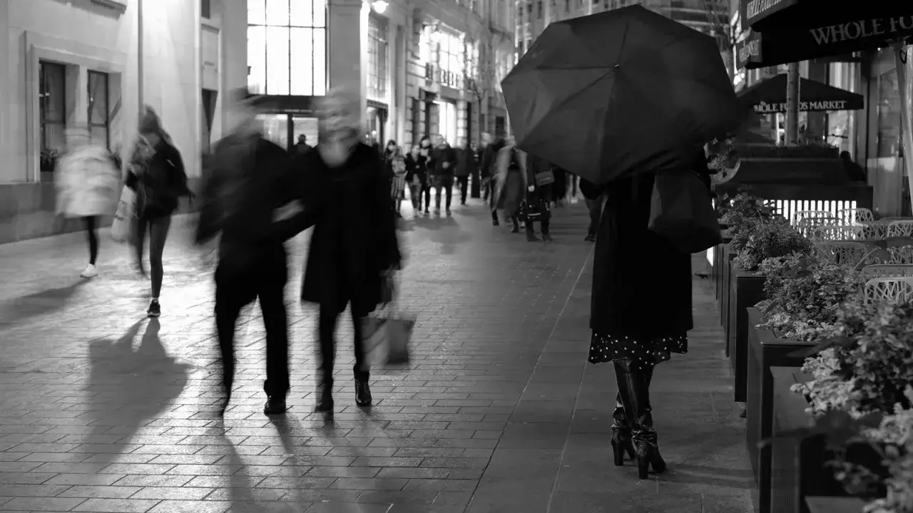 Nocna fotografia uliczna, gdzie rozmyte postacie idą chodnikiem. Czy to legalne?