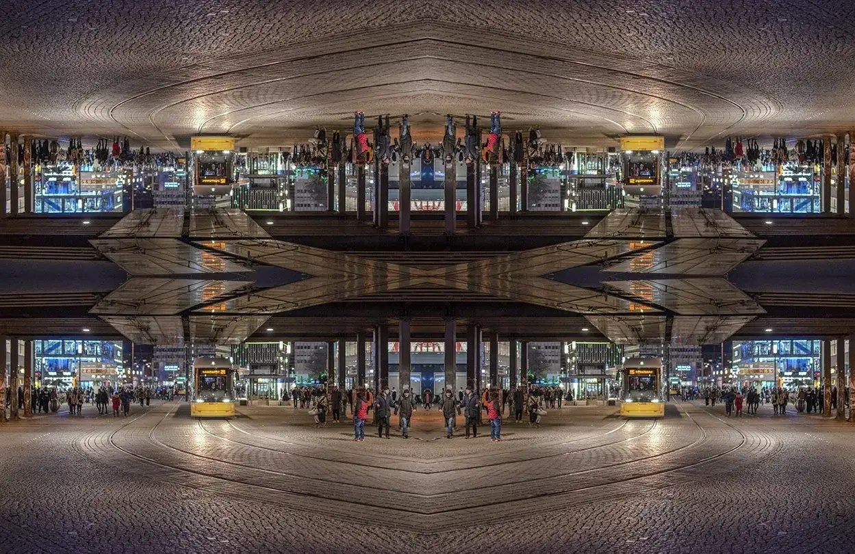 Nocne miasto z żółtym tramwajem i ludźmi. Kompozycja symetryczna tworzy surrealistyczny obraz.